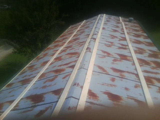 Rusted metal roof panels with new wood purlins before replacement — Storm Damage Roof Repair in Great Meadows by Roofing Brothers