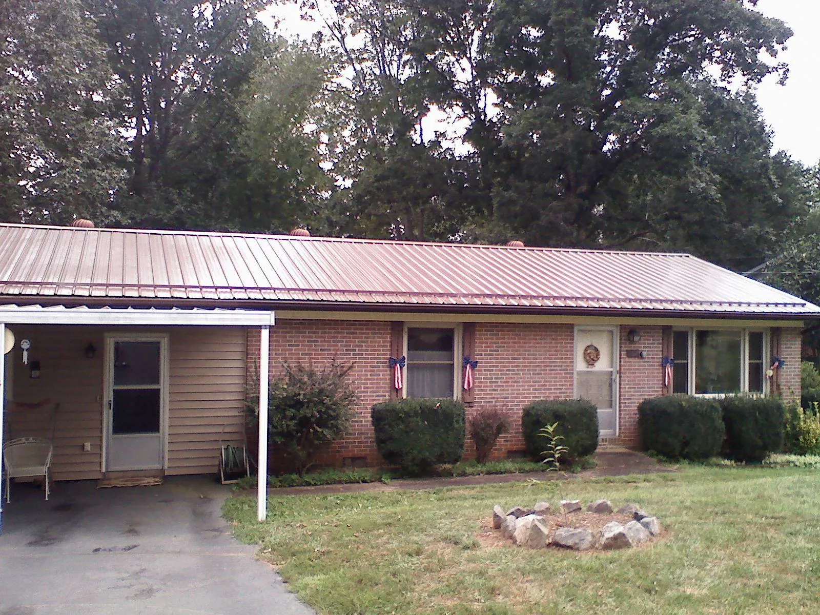 Bronze metal roof and carport on a brick ranch home — Roof Repair work by our crew in Great Meadows